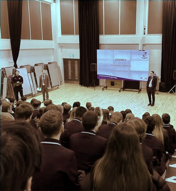 A Spark speaker addressing students in a school hall